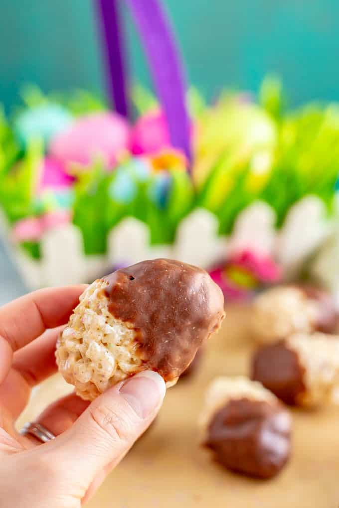 A chocolate dipped Easter egg Rice Krispie treat being held
