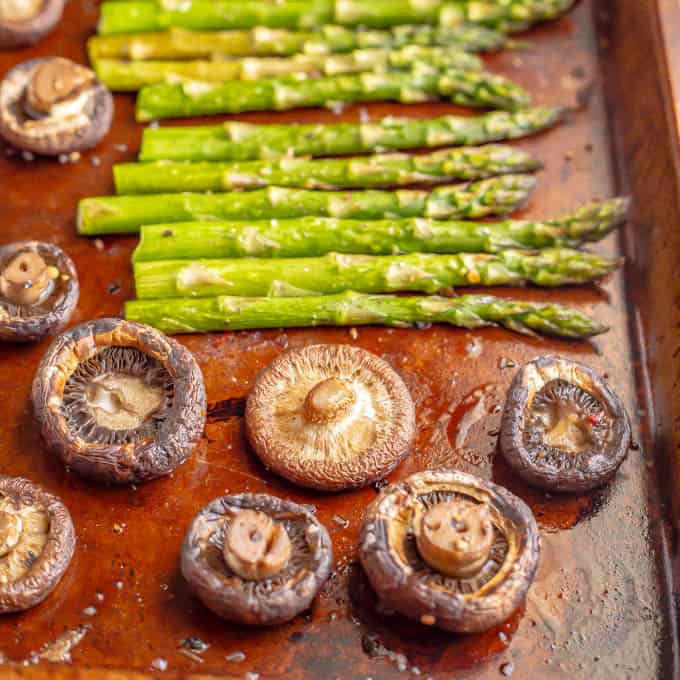 Asparagus and wild mushrooms on a baking tray after being roasted in the oven