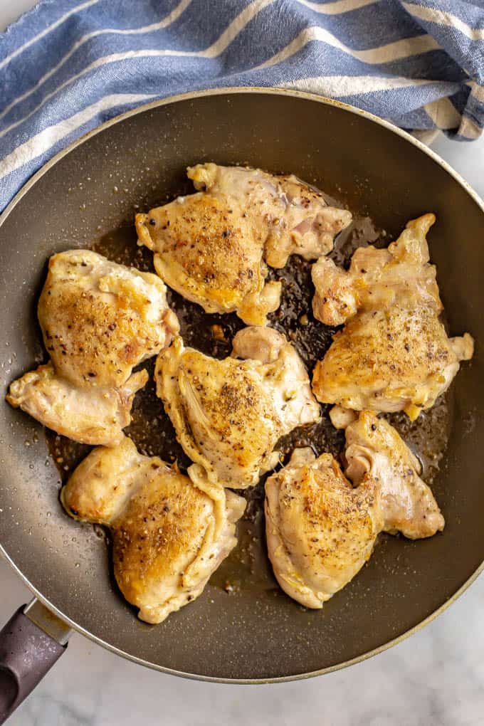 Chicken thighs seared in a large pan