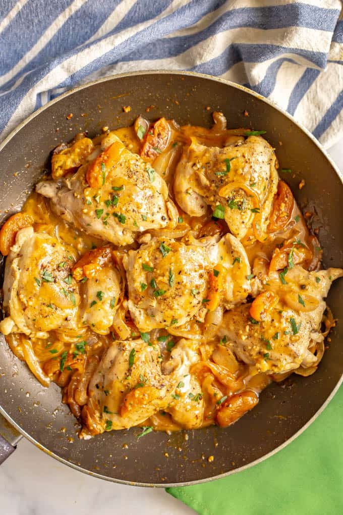 Chicken thighs cooked in a large skillet with a creamy pan sauce of onions, apricots and broth