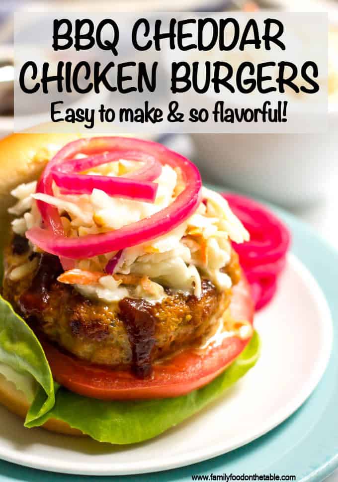 Close up of an assembled BBQ chicken burger on a bun on a white plate.