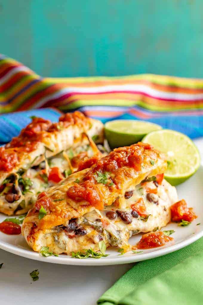Cheesy Mexican stuffed chicken breasts are filled with black beans, tomato and cheese and topped with taco seasoning and more cheese for an easy, fun and delicious family dinner! #stuffedchicken #cheesychicken #chickendinner #dinnerideas