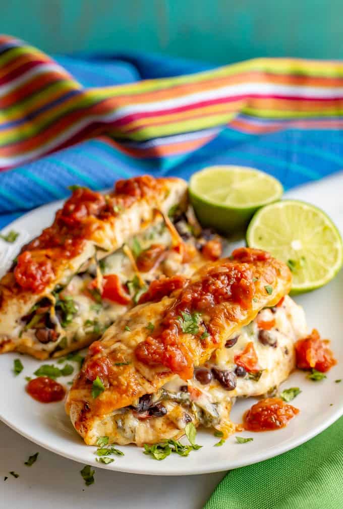 Cheesy Mexican stuffed chicken breasts are filled with black beans, tomato and cheese and topped with taco seasoning and more cheese for an easy, fun and delicious family dinner! #stuffedchicken #cheesychicken #chickendinner #dinnerideas