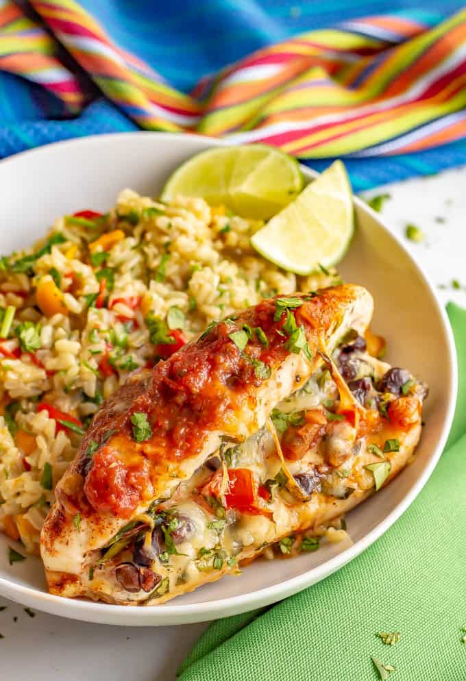 Cheesy Mexican stuffed chicken with confetti rice in a large white bowl