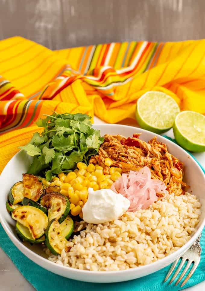 Salsa chicken grain bowls are full of juicy, tender chicken, fluffy grains, fresh and sautéed veggies and tons of toppings. Great for meal prep or an easy dinner! #chicken #grainbowls #mealprep #healthyeating