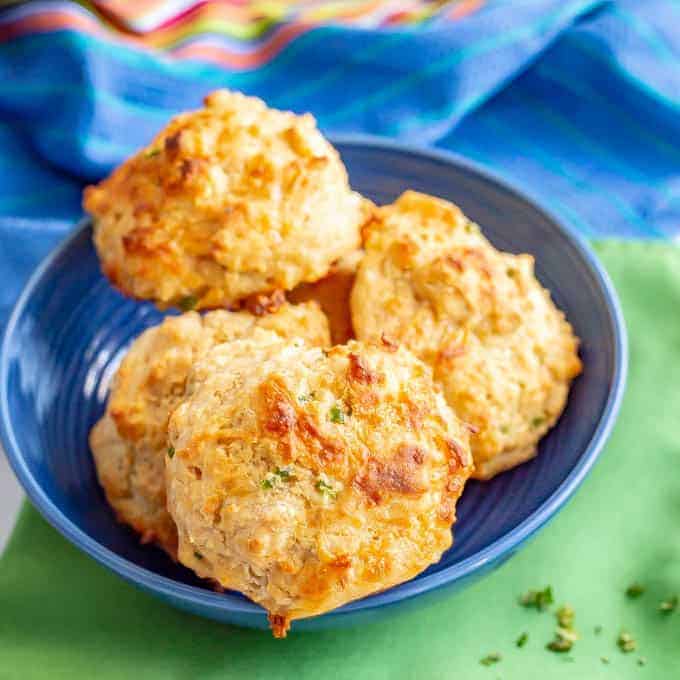 A blue bowl filled with jalapeño cheddar drop biscuits