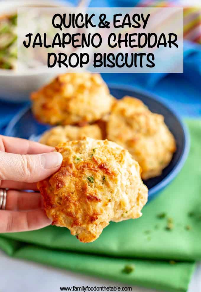Someone holding up a drop biscuit with the recipe title in text on the photo