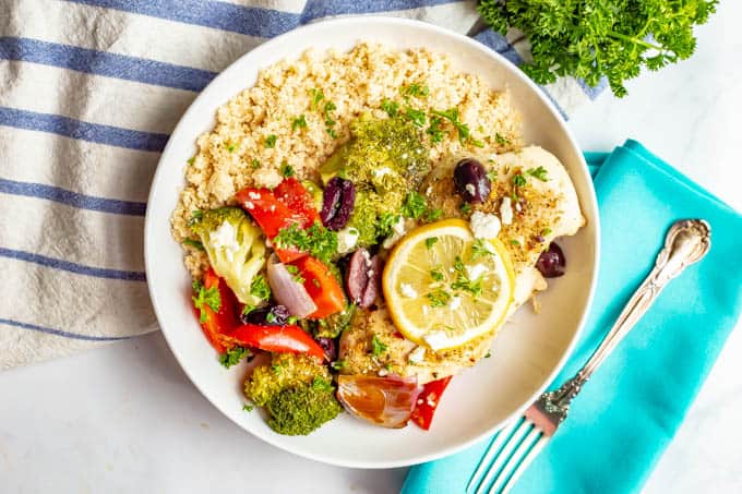 Chicken and vegetables with brown rice served in a large white bowl