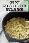 A large dark pot with brown rice mixed with chopped broccoli and melted cheddar cheese