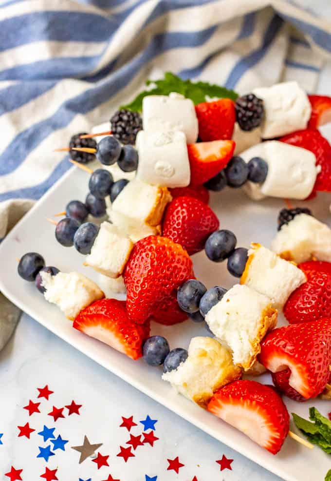 Red white and blue fruit snacks on a white plate with stars on the table for decoration