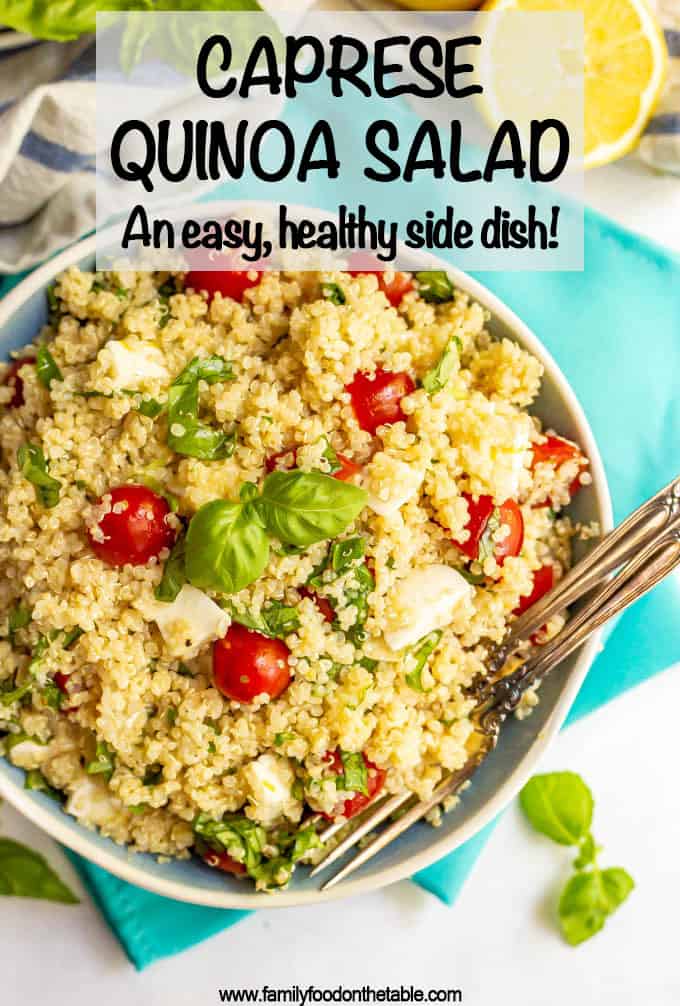 Bowl of quinoa salad with tomatoes, mozzarella and basil with two forks on the side