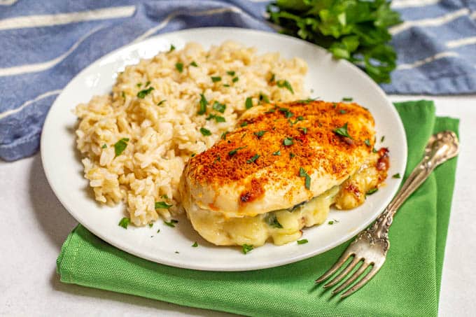 Baked stuffed chicken breast with spinach and mozzarella cheese served with brown rice and topped with fresh parsley