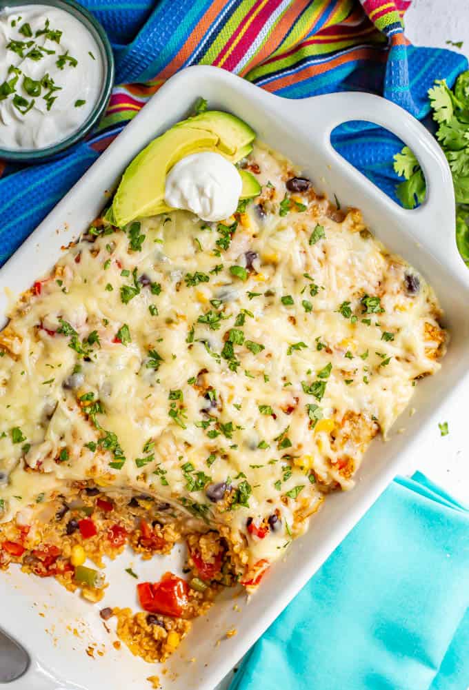 Chicken quinoa casserole baked in a large white dish with a scoop taken out