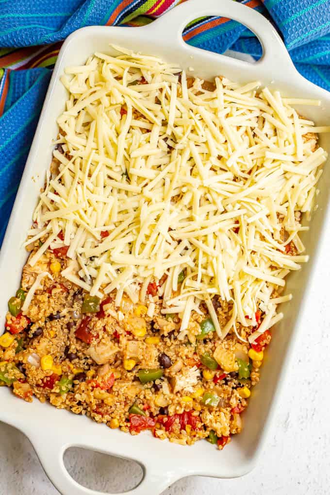 Southwestern chicken quinoa casserole with shredded cheese on top, before baking in the oven