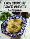 Crunchy chicken breasts served on a decorated blue plate with red wine in the background