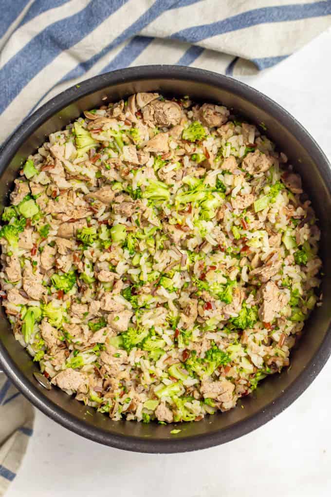 A large pot with cooked wild rice, broccoli and turkey sausage all mixed together