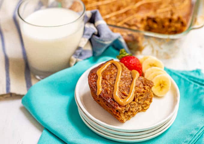 Peanut butter banana baked oatmeal served on a white plate with a drizzle of peanut butter on top