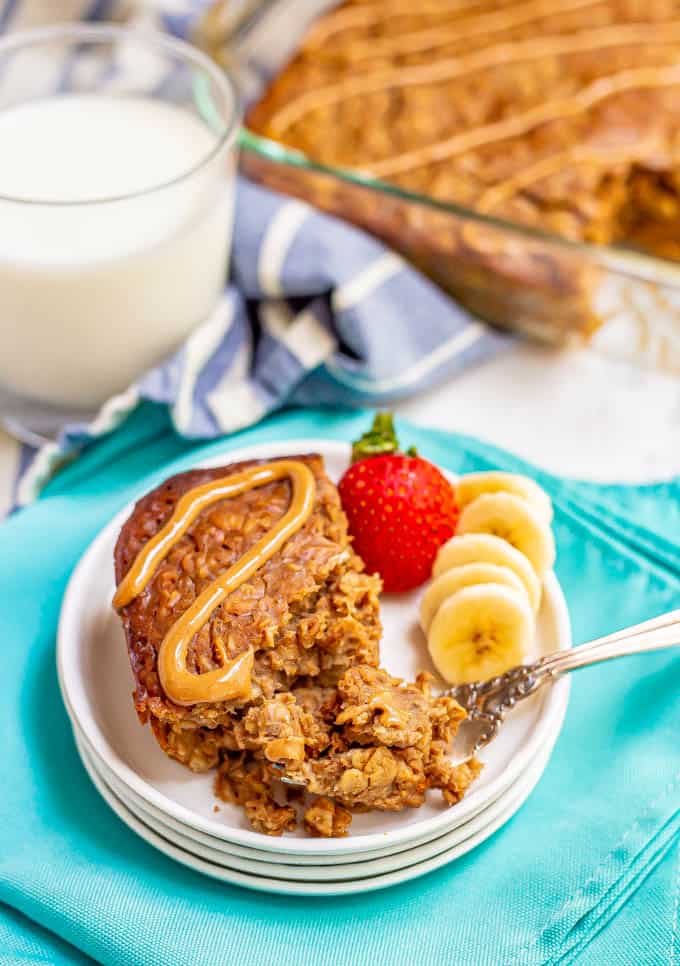 A slice of peanut butter banana baked oatmeal served on a plate with a forkful resting to the side