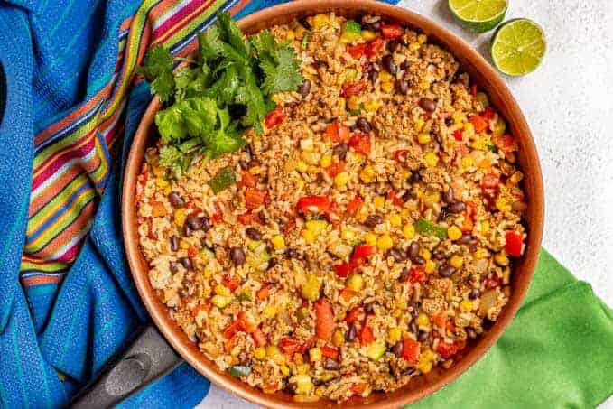 A skillet of turkey, rice, beans, corn, peppers and cilantro for garnish