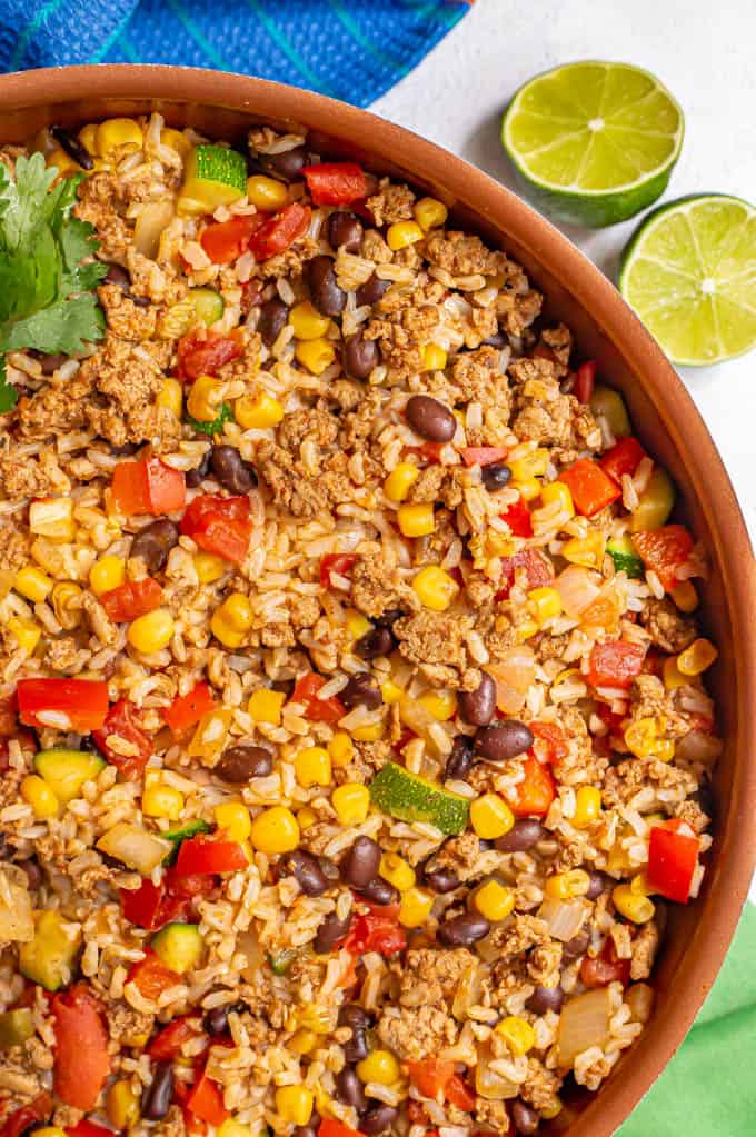 Close up of a large skillet filled with mixed ground turkey, brown rice, black beans and veggies