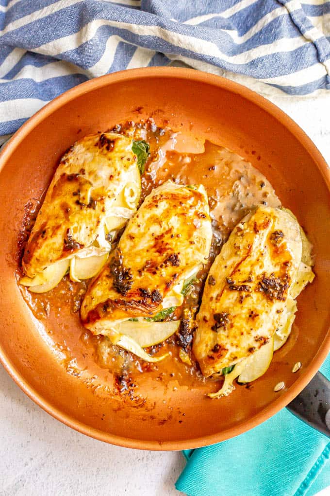 Pan seared chicken breasts with cheese and apples in a large skillet