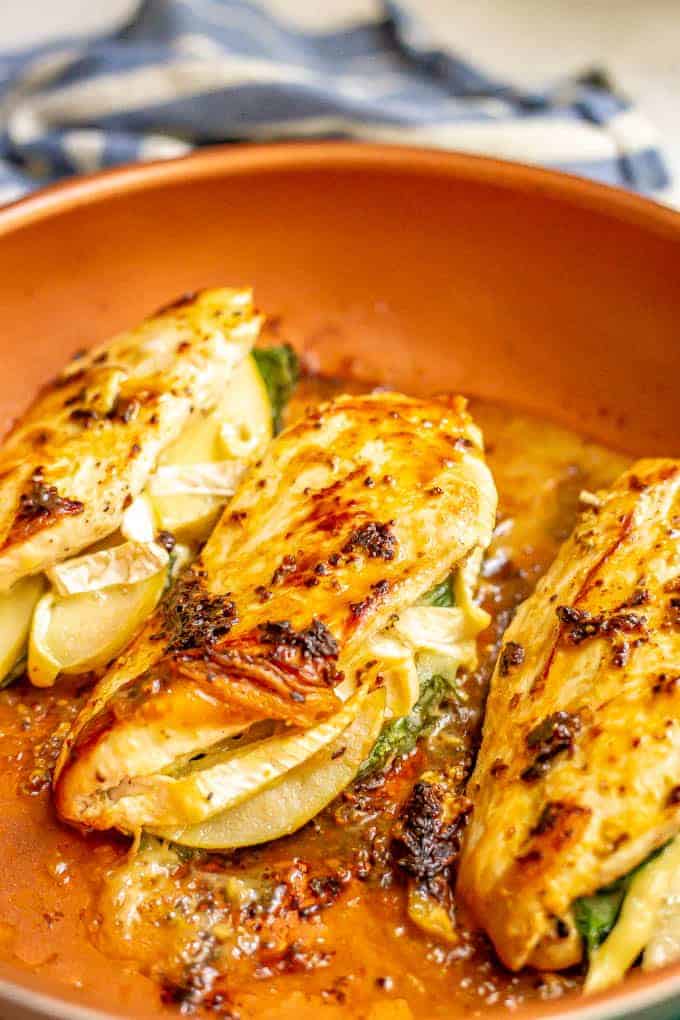 Pan seared chicken breasts with cheese and apples in a large skillet