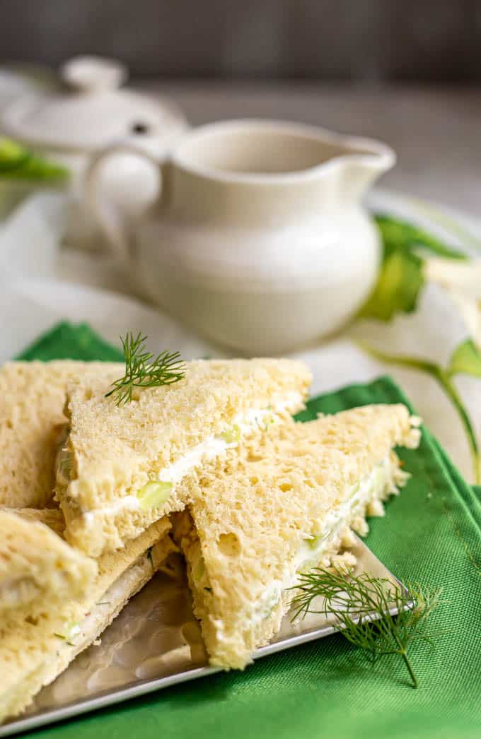 Tea time place setting with mini finger food sandwiches on a silver tray