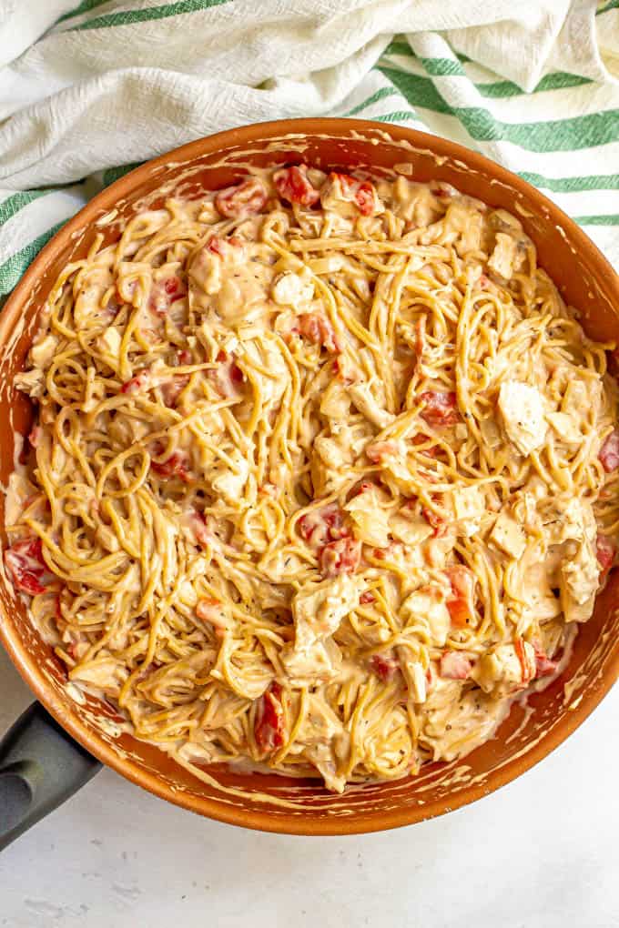 Spaghetti with chicken, tomatoes and a creamy sauce mixed together in a large pan