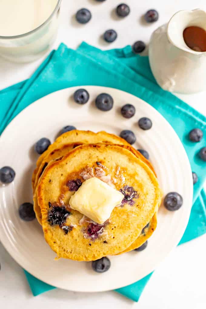 A stack of fluffy blueberry pancakes with a pat of butter on top