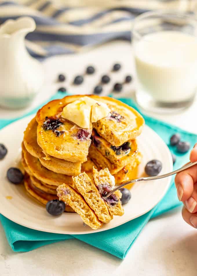 A forkful of pancakes being taken out of a stack