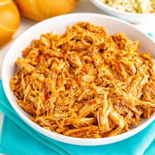 Large white bowl of shredded Instant Pot pulled pork with BBQ sauce
