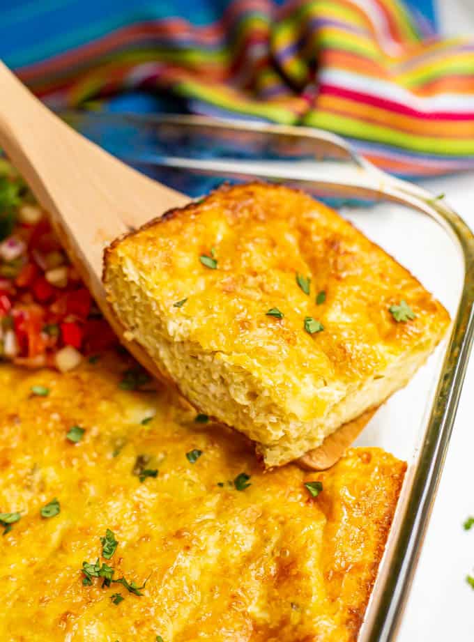 A slice of Mexican baked eggs being lifted out of a casserole dish