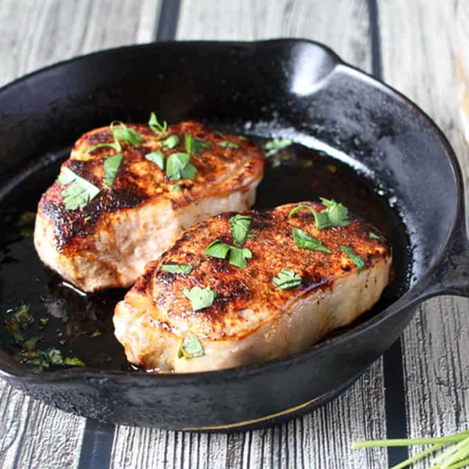 Côtes de porc avec un frottement sec saisies dans une poêle en fonte