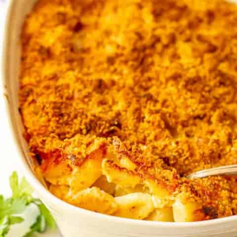 Baked macaroni and cheese casserole with a spoonful being taken out