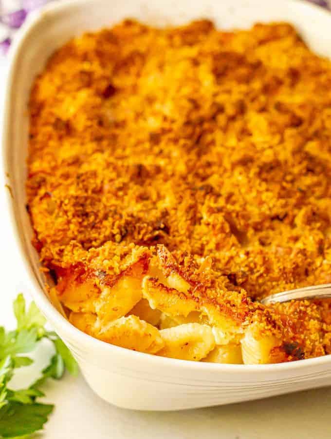 Baked macaroni and cheese casserole with a spoonful being taken out