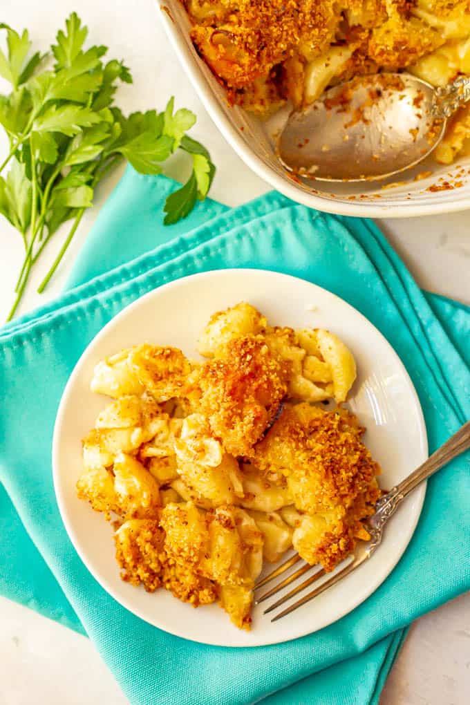 Crunchy baked mac and cheese served on a white plate with a fork