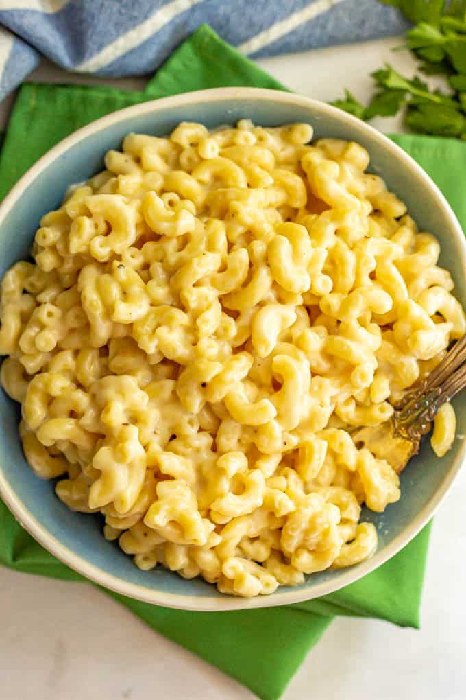 A bowl of easy mac and cheese with two forks alongside and green napkins underneath