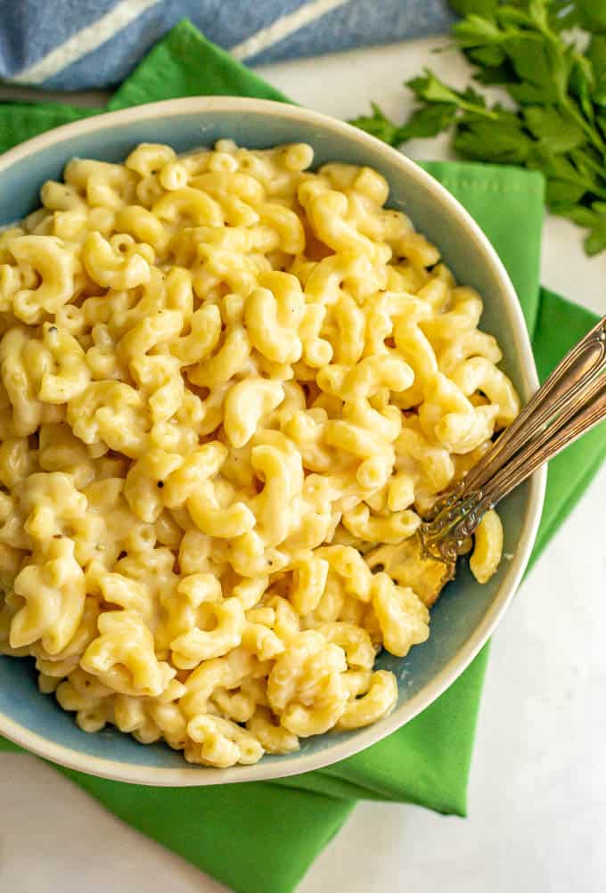 A bowl of mac and cheese with two forks lying on the side