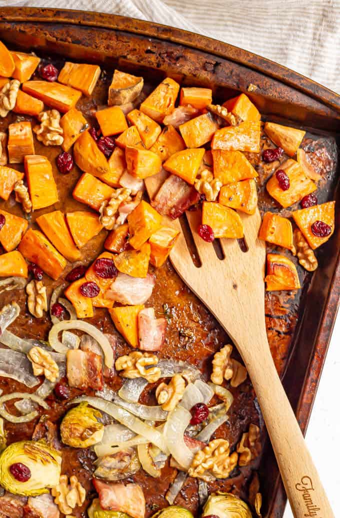 Roasted sweet potatoes on a sheet pan with walnuts and dried cranberries