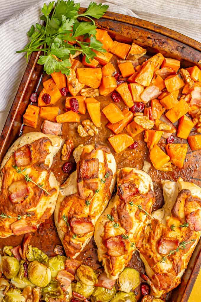 Sheet pan harvest chicken and vegetables is loaded with tender, juicy chicken breasts, sweet potatoes, Brussels sprouts, bacon and more for a warm, delicious, easy dinner! #sheetpan #chickenrecipes #chickendinner #dinnerideas #easyrecipe