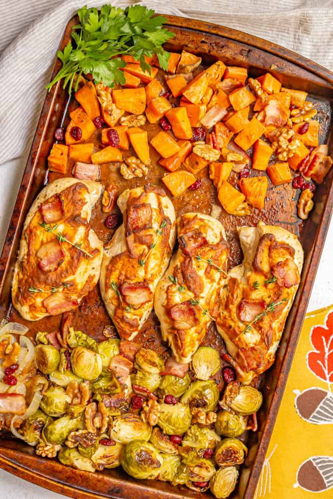 Sheet pan harvest chicken and vegetables is loaded with tender, juicy chicken breasts, sweet potatoes, Brussels sprouts, bacon and more for a warm, delicious, easy dinner! #sheetpan #chickenrecipes #chickendinner #dinnerideas #easyrecipe