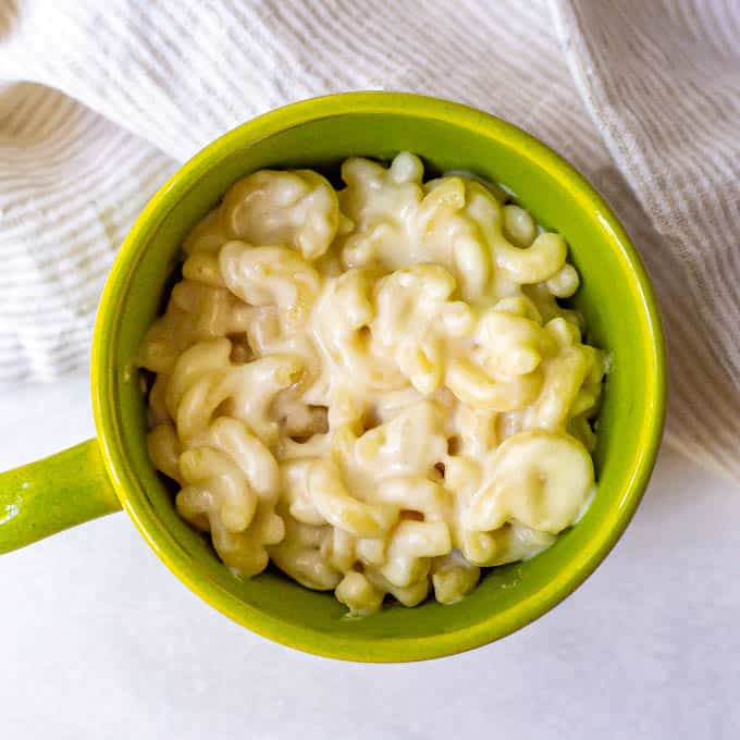 Creamy microwave macaroni and cheese in a green mug