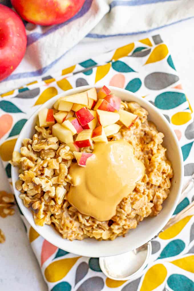 Warm oatmeal with apples, walnuts and peanut butter on top