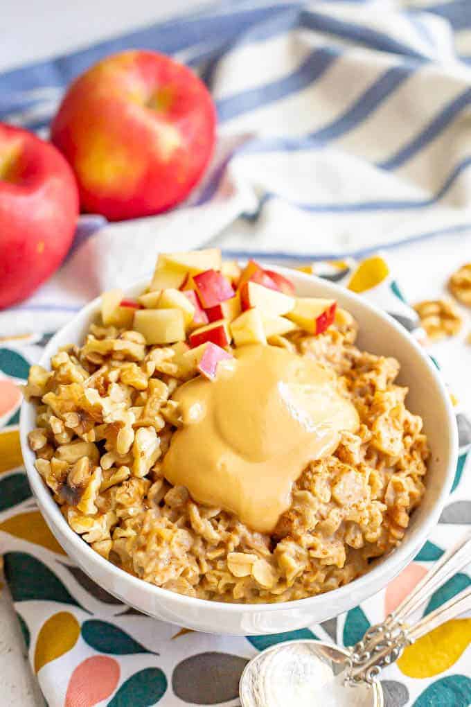 Peanut butter oatmeal with cinnamon, apples and walnuts is a healthy, hearty and delicious fall breakfast! This 10-minute recipe is sure to warm you up and fuel your morning! (GF, DF, V) #oatmeal #apples #breakfast #protein #healthybreakfast