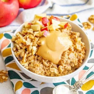 Cooked oatmeal with toppings served in a white bowl