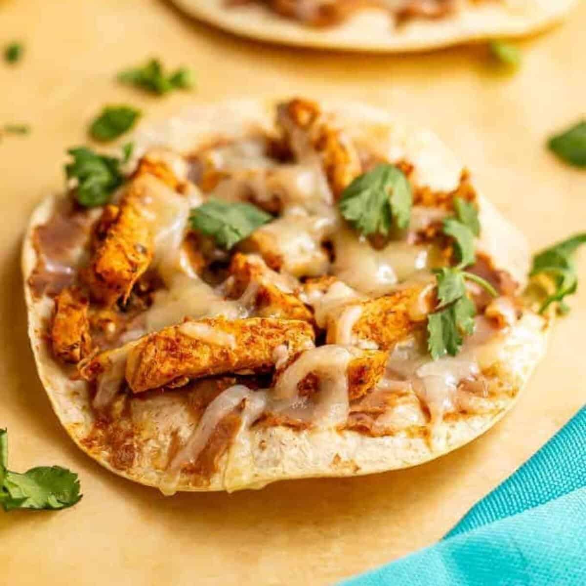 Cheesy turkey tostadas on parchment paper after baking in oven