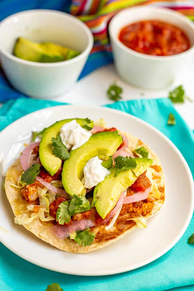 Leftover turkey tostada with toppings on a colorful napkin