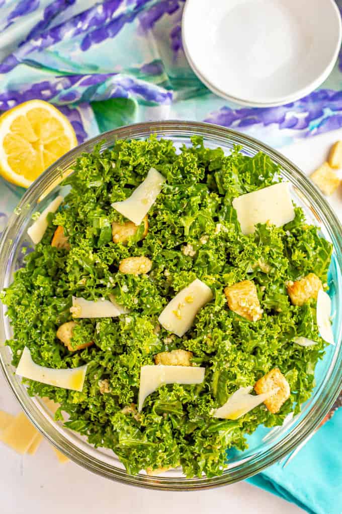 Caesar salad with kale, Parmesan and croutons in a glass bowl in a half lemon