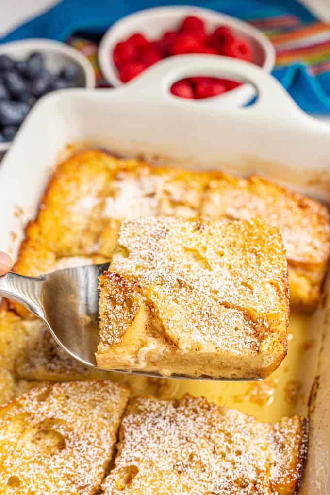 A slice of French toast casserole being lifted out of the baking dish