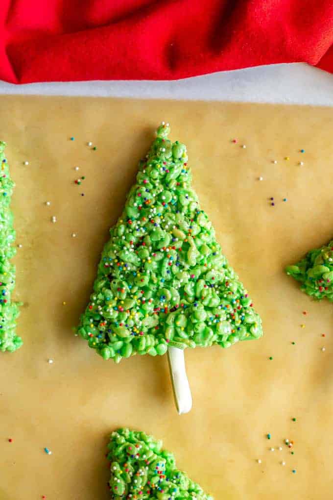 Christmas tree made of Rice Krispies cereal and decorated with sprinkles and a white chocolate covered pretzel stem